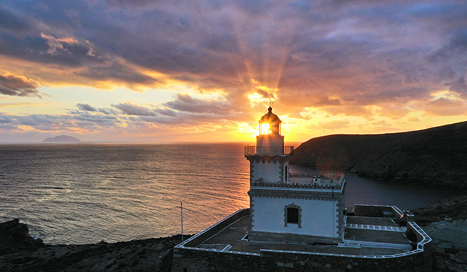 Drone shot of lighthouse at sunset in Serifos, Greece